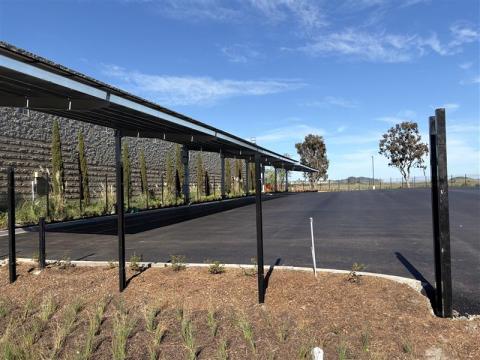 Paved parking lot with solar panel canopies and landscaping.